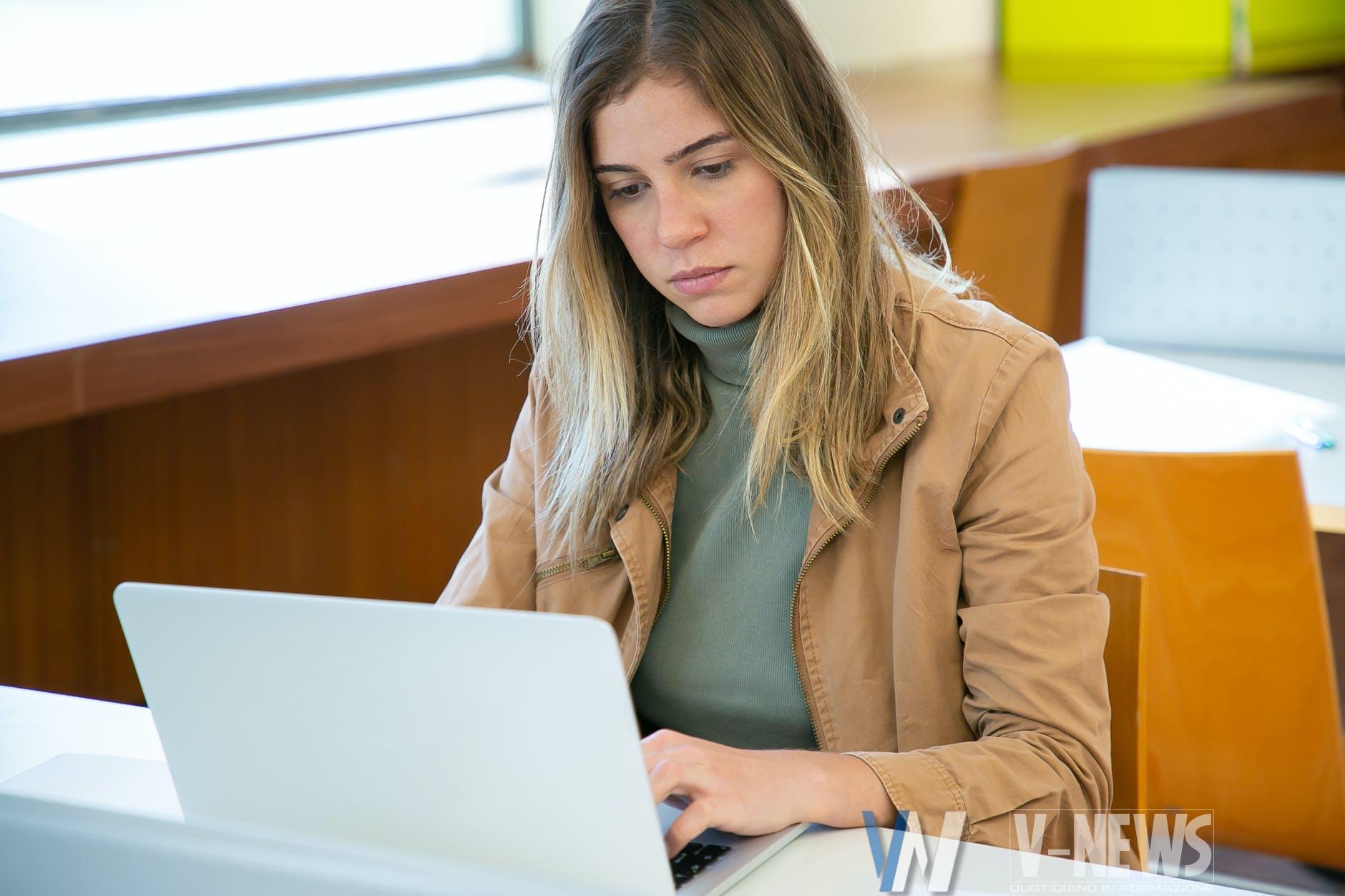 serious woman working on laptop in library
