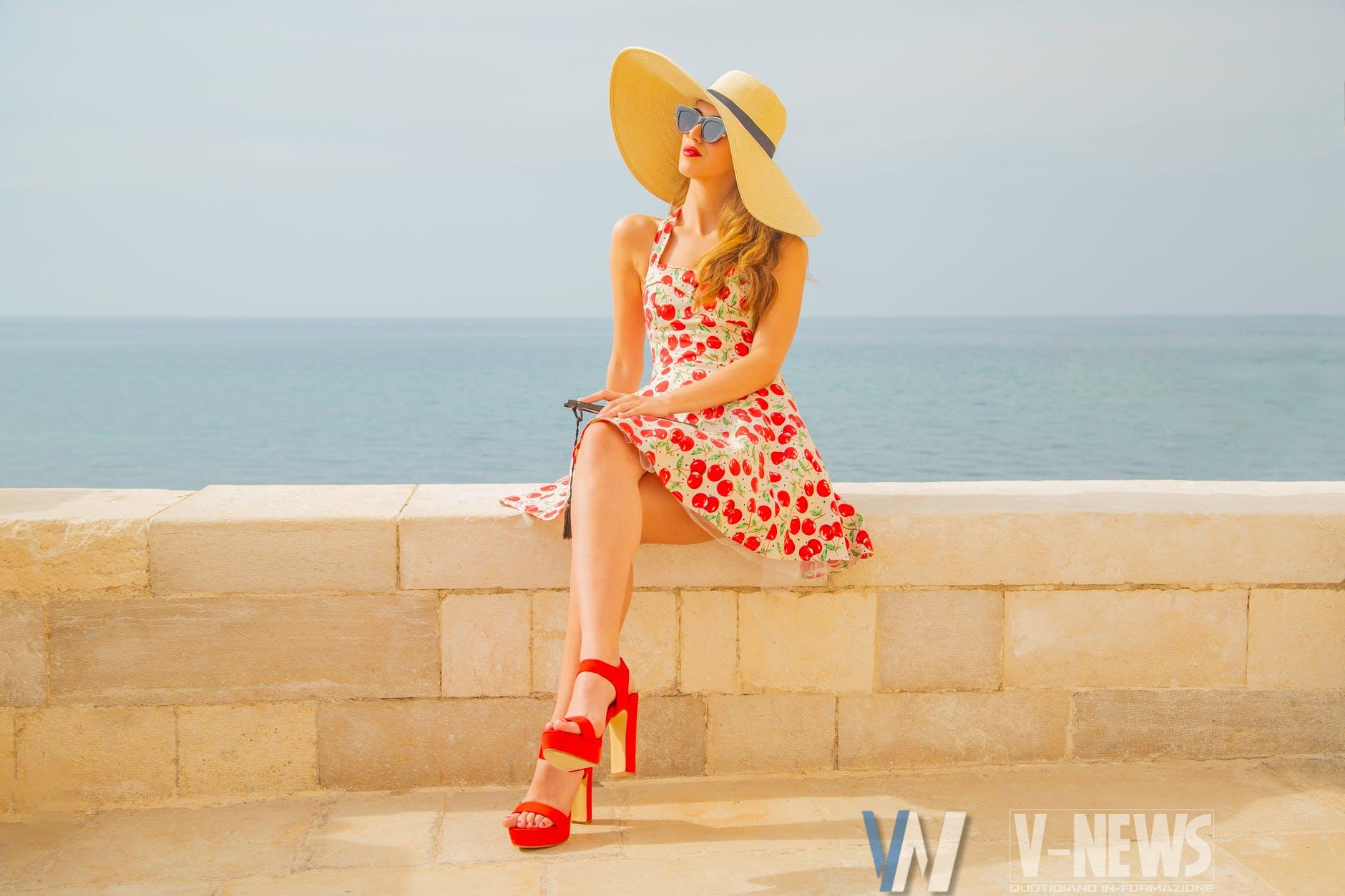 woman in red and white floral dress wearing brown sun hat