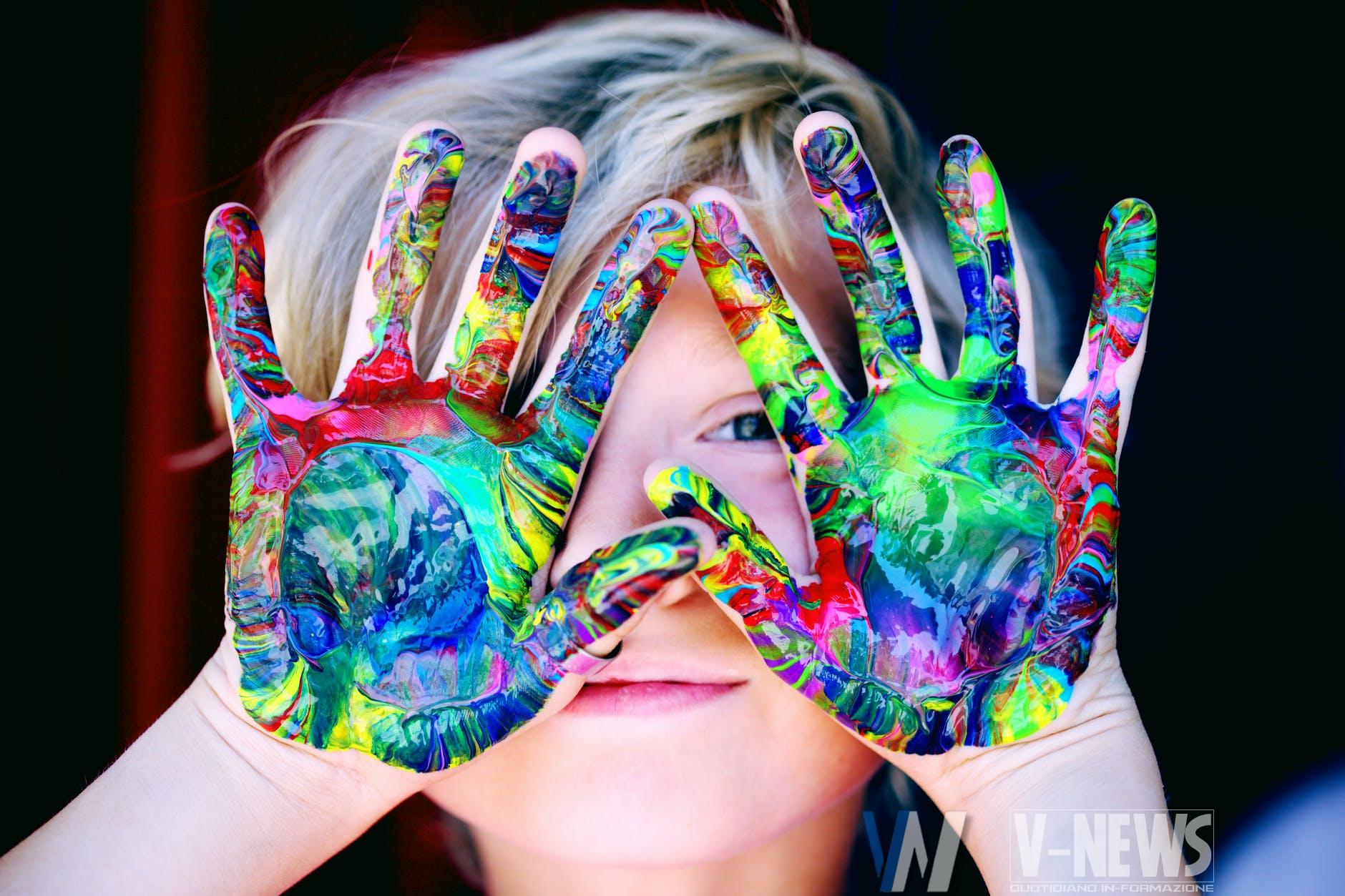 a kid with multicolored hand paint